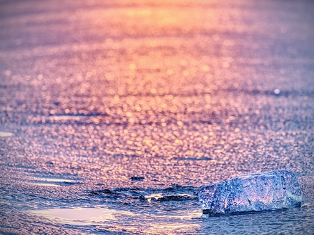 Ice piece in selective focus photo. Detail view in deep ice and frozen bubbles in broken ice.の写真素材