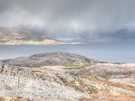 Colorful seascape with rocky coastline. The low afternoon sun, cloudy sky touch the oacean at the horizon.の写真素材