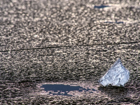 Detail of  frozen icy sheet. Ice cracks forming surface,  floes flowing on cold river water during...