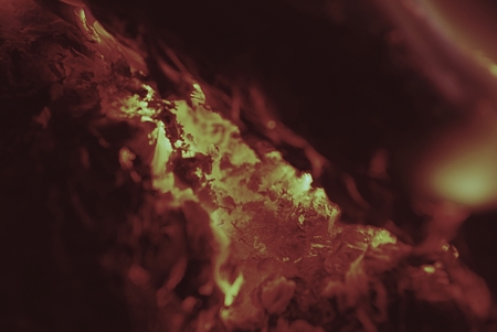 Natural firewood in the fireplace, detail view into BBQ fire burning hardwood,  background barbeque...