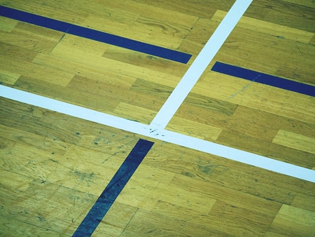 Hall floor in a gymnasium with crossed lines. Contour lines of basketball and handball playgrounds. Reflection in polyurethane varnishの写真素材