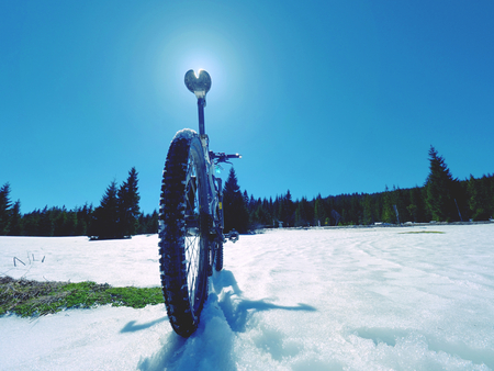 Cycling on large tyres in fresh snow. Biker goes by bike on the snowy road in the mountains. Picture taken in HDR mode.の写真素材