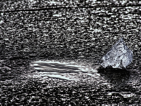 Structured frozen mud. Shore of frozen puddle against to the sunlight.