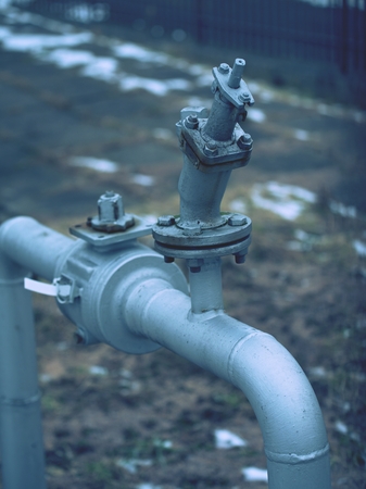 Flanges and valves are mounted on a ground made of welded steel pipes. Metal pipe flanges with bolts...