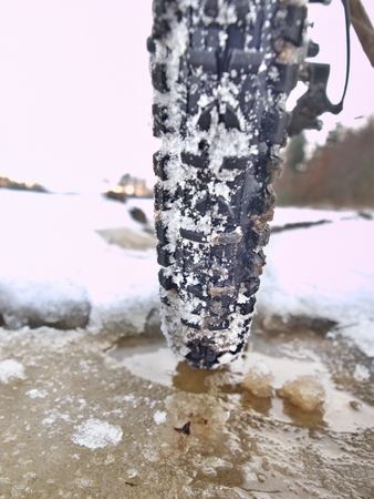 Mudd and water drops on bike tyre. Winter free ride in snowy landscape.  low temperature, cloudy sky.の写真素材