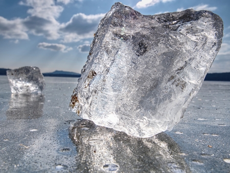 Shining  ice splinters and pieces of ice on  the frozen river or lake, winter themeの写真素材