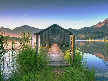 Old wooden dock houses on the lake with typical wooden pier,  the Walchensee in Bavaria Germanyの写真素材