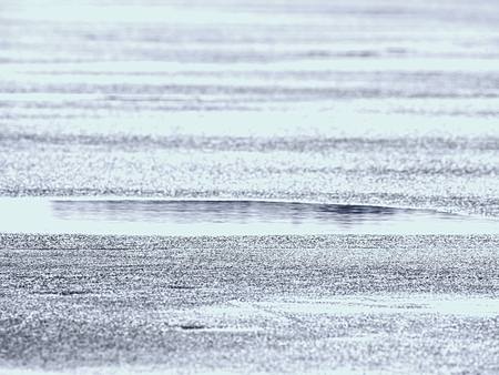 Mirroring of icy cracks on level of frozen lake. Abstract blurry focus. Texture of glacier ice....