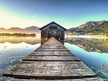 Old wooden dock houses on the lake with typical wooden pier,  the Walchensee in Bavaria Germanyの写真素材