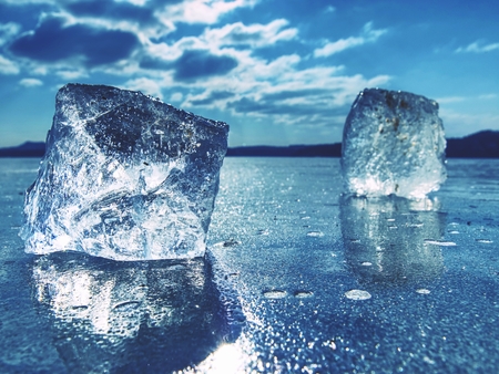 Ice floe at frozen surface with many reflection, blue sky in background. Winter frozen lakeの写真素材