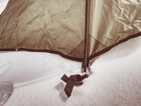 Detail of tent anchorage on snow. A snow storm came within  night and cover the  landscape with fresh powder snow.の素材 [FY310105109154]