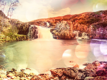 Pools and waterfalls within cloudy day in Scotland. Cold water falling from steps of sharp giant rocks.  Hipster filter.の写真素材