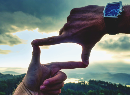 Hands framing view distant over sunset, vintage filter. . Close up of hands making frame gesture.の写真素材