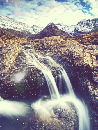 Popular trek. Waterfall between sharp exposed rocks, the Fairy pools on the Isle of Skye, Scotland. Hipster filter.の写真素材