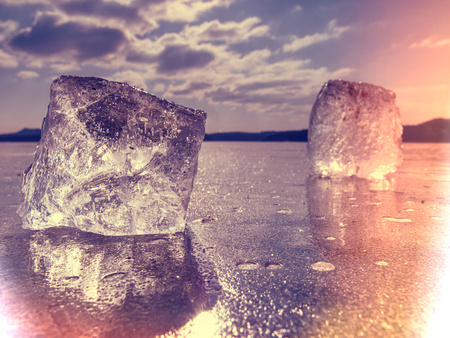Ice in flames.  Image of pieces of ice and drops of water on frost ground. Freeze evening. Hipster...