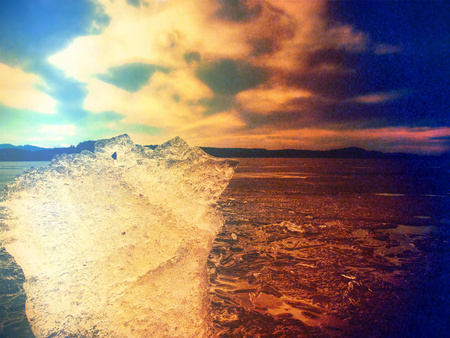 Clear ice in color spectra. Crystal clear piece of ice, scratches ancd frozen bubbles .. Hipster...