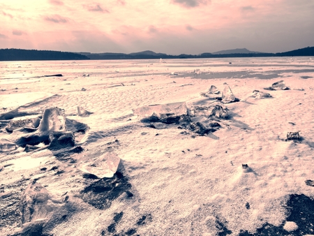 Ice breaking in pure nature. View over frozen water lake with sunset sky background,  winter natura landscapeの写真素材