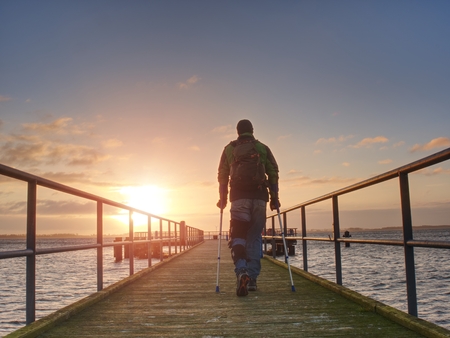 man silhouettes on a bridge against the setting sun, clear colorful skyの写真素材