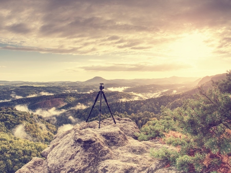 Mountain landscape with a tripod in the foreground ready on the edge.  Exposed rocky view point.の写真素材