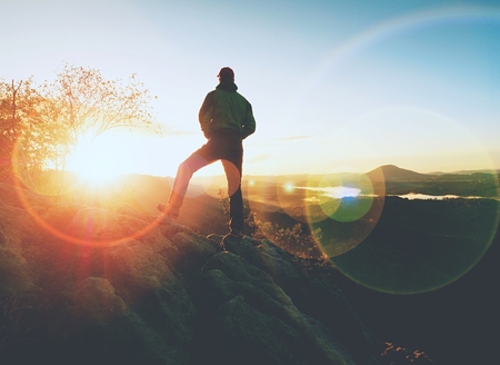 Man walking on the edge of a cliff at summit. Hrensko range,  Czech Republic 21st of Seprtember 2018.  Climber enjoying beautiful nature view at sunset after challenging climbの写真素材
