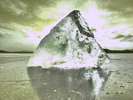 Ice breaking. Floe on frozen lake with sunset sky background,の写真素材