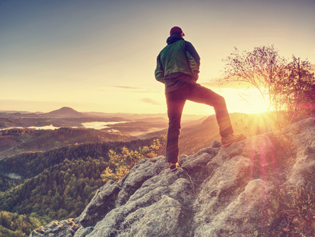Traveler on mountain summit enjoying aerial view over misty countryside. Travel Lifestyle success adventurの写真素材