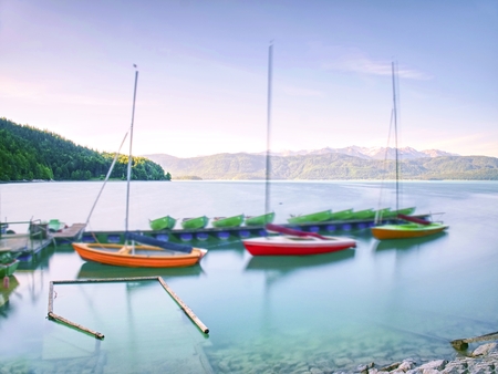 Warm afternoon in soft green and blue light and canoe in lake. Mountain rangeの写真素材