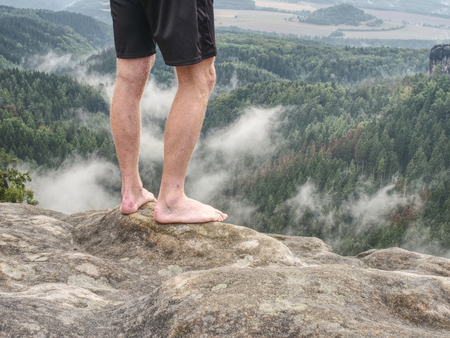 Couple resting on the top of the mountain after climbing. Deep valley below
