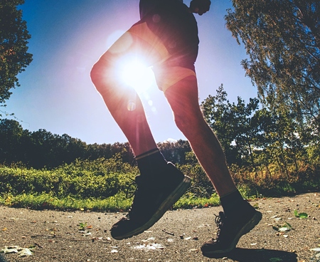 Sportsman within exercise in park. Man is running or jumping, stretching his body. Good health...