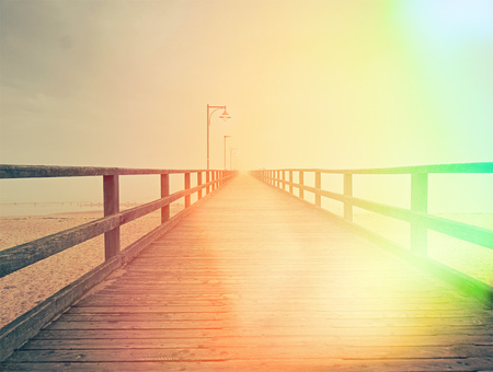 Wooden bridge on a sea dock. Pier on the coastline. Sea coast.  Hipster filter.の写真素材