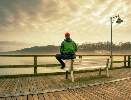 Man sitting in the bench on the Sea Bridge looking at the  horizonの写真素材