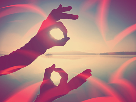 Abstract, over filtered.  Wrist makes the ok sign is all right by the sea in the summer, vintage effectの写真素材