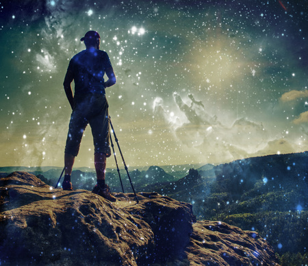 Abstract, over filtered. Man walking on the edge of sharp cliff high mountains above the precipice.の写真素材