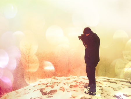 Man photographing magic misty landscape in winter the mountains.  Hipster filter.の写真素材