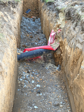 Open trench under pavement with hidden water pipes, electrical and internet wires, gas tubes and others utilities.の写真素材