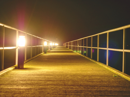 Long wooden pier on Baltic coast during early morning calm. Cold weather peaceful silent day. Empty mole no people.の写真素材