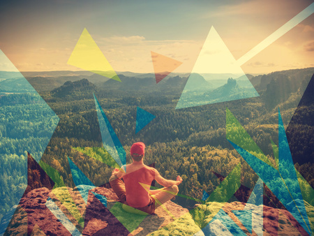 Man hiker sitting on a rock in mountain. Abstract, over filtered. Man sit. Fall mountain mist. Mist in valleysの写真素材
