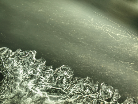 Frozen small mountain waterfall. Detail of rounded icicles with many reflections.の写真素材