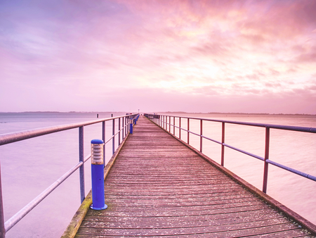 Wooden terrace mole or pier in Dranske. Wooden dock, blue sea and sky background. View of wooden bridge above smooth ocean.の写真素材