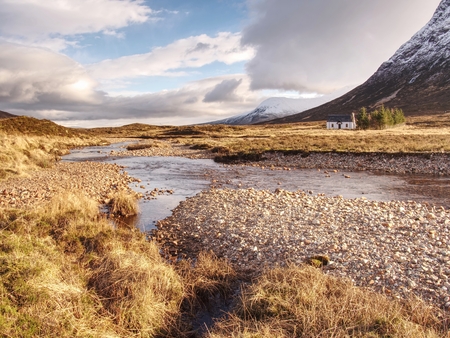 River at base of snowy mountains in Scottish Highlands near Glencoe  in winter. Cold windless winter morningの写真素材