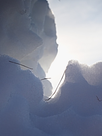 Piece of ice with strong contour and sun flares. Ice crystals on a ice plate