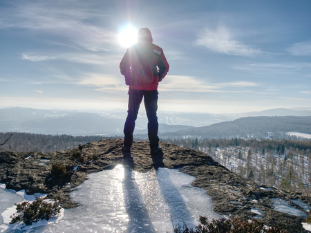 Hiker relaxing on top of hill and enjoying on sunny day. Tourist  trekking along a hillの写真素材