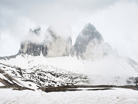 Spring trek around Tre Cime above snowy landscape.  Sunny April evening, view from tour around at...