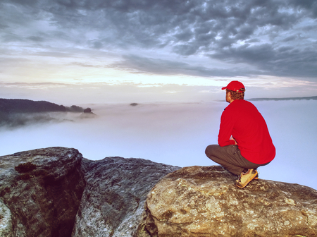 Viewpoint above heavy misty clouds in rocks.  Enchanted autumn landscape in fog in the morning.  Landscape with  orange red fog.の写真素材