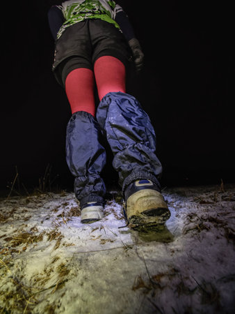 Night race runner in black yellow red jersey hold paper map. January 25th, 2019, Novy Bor, Czech Republic. Orienteering extreme night cup race.のeditorial素材