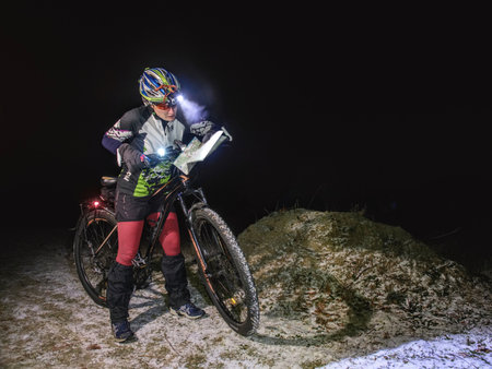 Winter night extreme bike racer control navigation and the map.  January 25th 2019, Novy Bor, Czech Republic. Outdoor orienteering check point activity. Extreme night cyclist competitionのeditorial素材