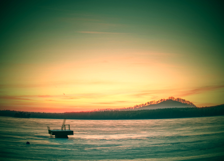 Frozen ice surface on lake with sunset backdrop. Aerial pattern on the frozen lake. Frozen lake ice captured with footprintsの写真素材
