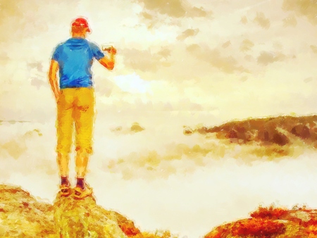 Effect watercolor paint.  Hiker blogger taking photo by smartphone of fall sunset mountains landscape. Sharing travel lifestyle and adventureの写真素材