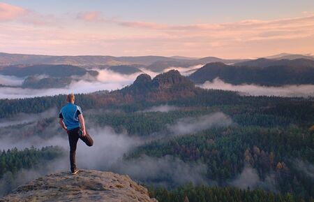 Man in warm jacket with backpack in spring rockx mountains. Travel concept.