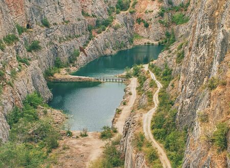Great old quarry for dolomite mining. Blue lagoon in middle with wooden bridge for tourists.の写真素材